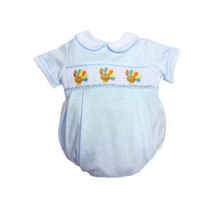 Dress your little one in playful charm with the Infant Boys Turkey Brandon Bubble from Zuccini Kids. Soft blue and white mini stripes create a gentle backdrop for the delightful smocked bubble, featuring colorful embroidered turkeys that add a whimsical touch. Comfortable and stylish, this bubble is perfect for keeping your infant cozy while standing out with unique, eye-catching details this Thanksgiving.