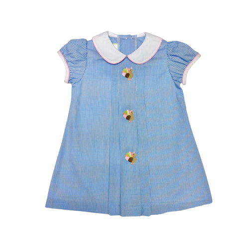 Dress your little one in timeless charm with the Girls Gingham Turkey Robyn Dress from Zuccini Kids. This festive dress features a crisp blue and white gingham pattern, a delicate white and pink piped Peter Pan collar, and a delightful turkey embroidery front and center. Perfect for Thanksgiving celebrations, it combines classic style with adorable holiday spirit, ensuring your toddler girl stands out as the season's little star. Comfortable and cute, it’s the ideal choice for memorable family moments espec