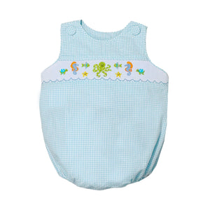 Dive into summer with the Infant Boy's Under The Sea Christopher Sunsuit from Zuccini Kids. This charming bubble features a refreshing teal and white check pattern complemented by an elegant smocked front adorned with delightful embroidered sea animals. This outfit transforms everyday play into magical underwater adventures. Perfect for beach outings, summer parties, or simply making a splash at daycare!