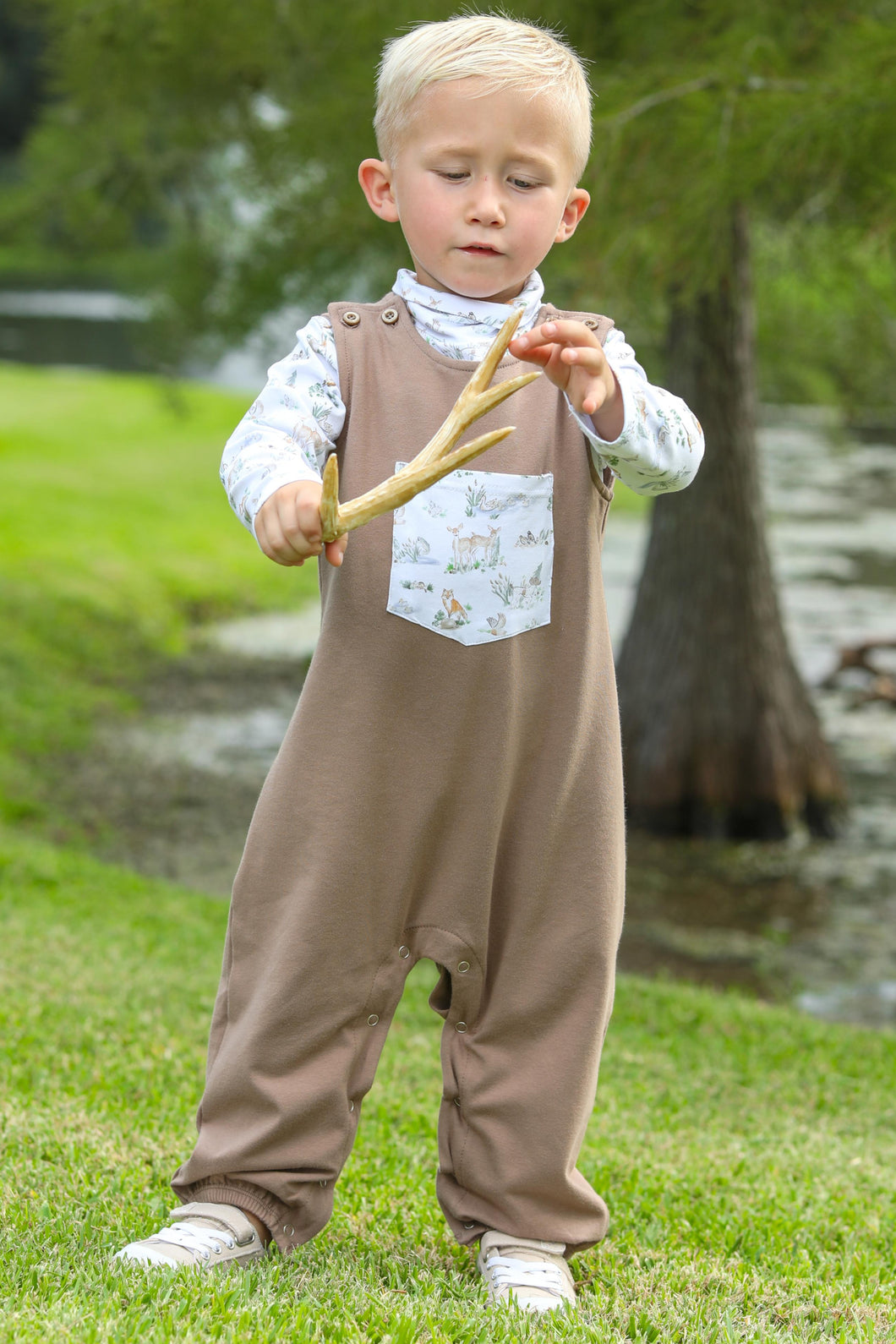 Dress your little one in cozy charm with the Woodland Friends Longall Set from Trotter Street Kids. This adorable set includes a soft brown longall featuring a playful printed front pocket, paired with a matching turtleneck adorned with delightful woodland creatures like ducks and deer. Perfect for infant boys, it combines comfort and cuteness, making it an ideal choice for everyday wear or special outings.