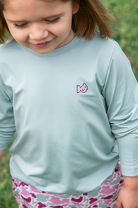 Meet the ultimate outdoor tee for adventurous girls and peace-of-mind moms! Girls' Pro Performance Long Sleeve T-shirt in Blue Surf with Pink Camo&nbsp;is made to move, protect, and play all day. Featuring our signature PRODOH logo with a pink camo border and "An Outdoor Tradition", this shirt adds a stylish twist to the functional favorite.