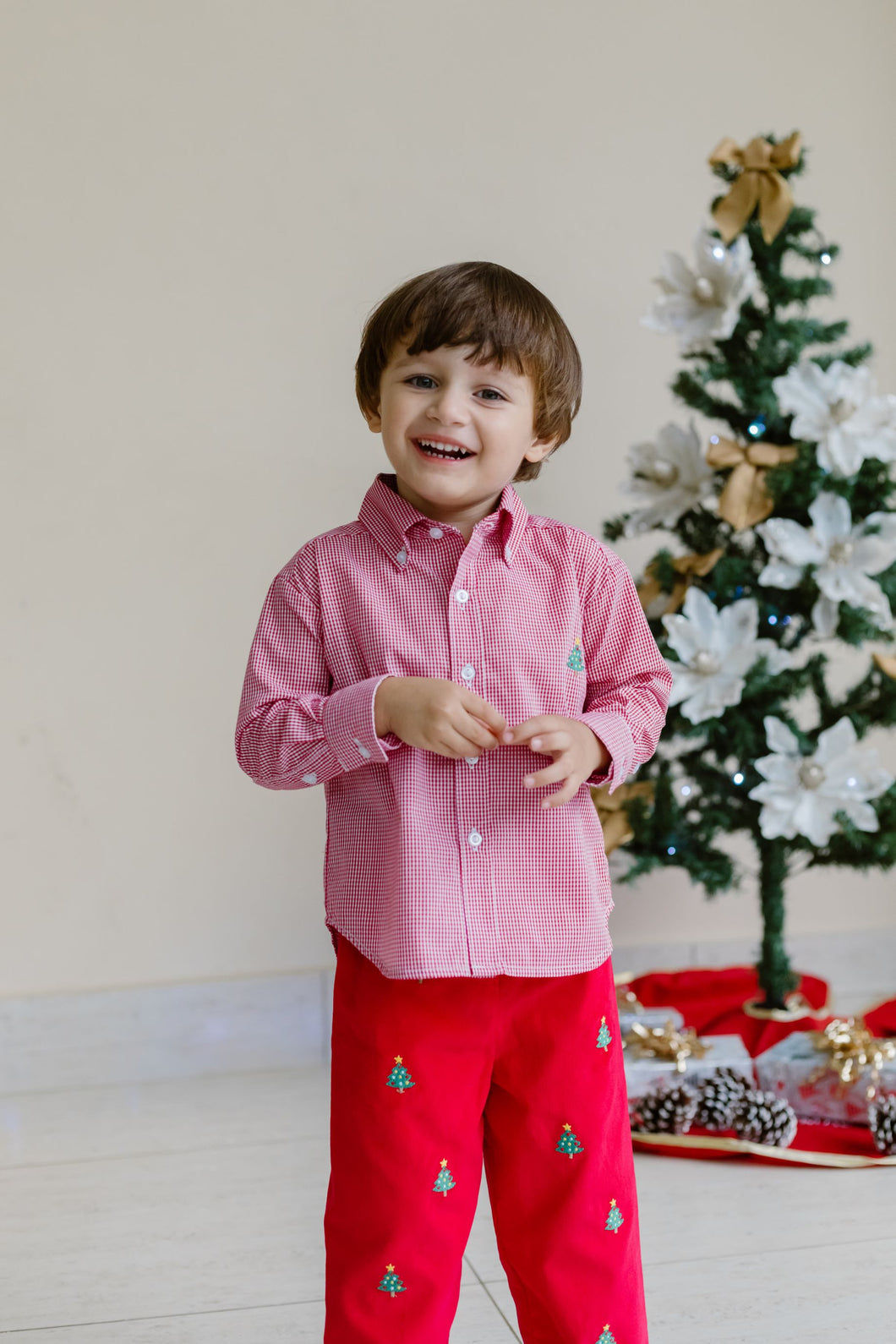 Celebrate the season in style with the Boy's Christmas Tree Alton Gingham Shirt from Zuccini Kids. This charming red and white gingham button up shirt t is adorned with a festive Christmas Tree embroidered detail. This shirt is the perfect holiday outfit for your son to shine and coordinate perfectly with sibling looks. Pair with the Christmas Tree Red Corduroy Pants.