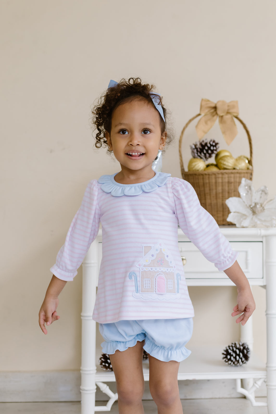 Dress your toddler in festive charm with the Toddler Girls Gingerbread Reagan Knit Bloomer Set from Zuccini Kids. This playful outfit features soft pink stripes and a delightful gingerbread applique, paired perfectly with coordinating blue bloomers for comfort and style. Ideal for holiday casual wear, it brings cheer to every celebration while allowing your little one to move freely. Plus, a matching legging set is available for big sisters, making it perfect for sibling holiday photos and family gatherings