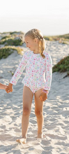Load image into Gallery viewer, Get ready to make a splash with our Floral Rash Guard One Piece Swimsuit! Designed by Funtasia Too, this adorable swimsuit features a cute pink, blue and green floral design on a white background. The rash guard style and ruffle waist accent make it both stylish and practical for your little one. Dive in now!

