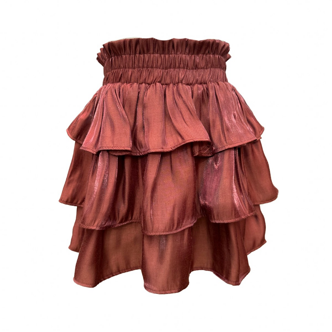 The Luna Skirt in Chestnut Shimmer from Pleat offers a dazzling tiered design that adds sparkle to every step. Perfectly crafted for tween girls, this skirt pairs effortlessly with the striped Oliva Flutter Top or Wren Top in Dashing, creating a stylish and versatile outfit. Its shimmering fabric makes it ideal for special occasions or everyday wear, giving your child a confident and playful look.