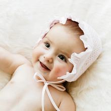 Load image into Gallery viewer, This smocked bonnet has got to be one of the most versatile girls bonnets to match every Feltman Brothers outfit she owns! This stunning bonnet features hand-made smocking with embroidered flowers, ruffled edges, and hanging ribbons for beneath-the-chin fastening.&nbsp;

Bonnet fits sizes 0-3m.
