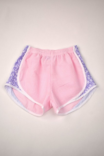 Upgrade your little girl's athletic wardrobe with our Pink Gingham & Lavender Track Shorts from Funtasia Too! These stylish pin shorts feature a beautiful lavender floral accent on the sides, adding a touch of feminine charm to her sporty look. Perfect for pairing with the Angel Tee!