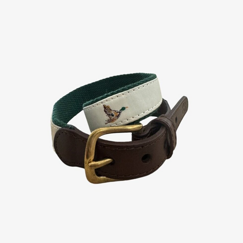 Elevate your little one’s style with the Boys In-Flight Mallard Belt from Velvet Fawn. Featuring charming flying mallard ducks on an off-white background, this belt blends classic design with a touch of the outdoors. The green knit backing ensures durability and comfort, while the brown leather and gold closure add a refined finish. Perfect for boys who love adventure and timeless fashion, this belt is a versatile accessory that completes any outfit with effortless charm.