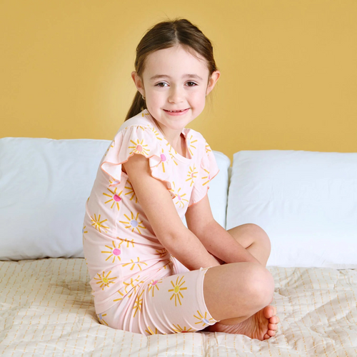 Brighten bedtime with the Put on Your Sunnies Pajama Short Set from Magnetic Me. Featuring a cheerful sun print on a coral pink background, this set combines comfort and convenience. Made from soft, stretchy modal fabric, it moves with your child for all-night comfort. The magnetic snap on the shoulder makes dressing effortless, while the short sleeve shirt and matching shorts keep your little one cool and cozy. Perfect for easy wear and sweet dreams.