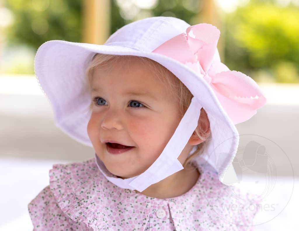 Our girls hat features an adjustable chin strap with an ultra-soft fastener and reverses to a solid white for maximum versatility. An Add-A-Bow slot lets you accessorize with your favorite Wee Ones bow (bow sold separately). UPF 50+ provides protection from the sun. 100% cotton.