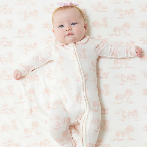 This charming footie combines a classic pink and white farm toile print with a timeless Peter Pan collar, creating an adorable look for your little one. Crafted from soft modal fabric, it offers gentle comfort and easy movement. The convenient two-way zipper makes diaper changes quick and hassle-free, while the ribbed texture adds subtle style and extra stretch. Perfect for keeping your baby cozy and cute throughout the day.