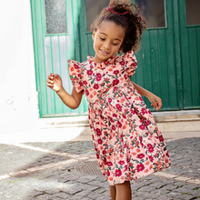 Load image into Gallery viewer, Fresh As A Daisy! A patch of wild daisies in shades of red, orange and white springs from a blush colored ground in our Pink Daisy Floral shown here on our Girls Jennifer Dress. This short sleeve flock favorite silhouette delights with its feminine ruffled neck and sleeves and fully gathered, two tiered skirt that spins like a dream. Invisible zipper. A silver thread woven throughout adds a touch of shimmer and shine. Match back to Little Sis in our Baby Girls Jennifer Bubble.&nbsp;
