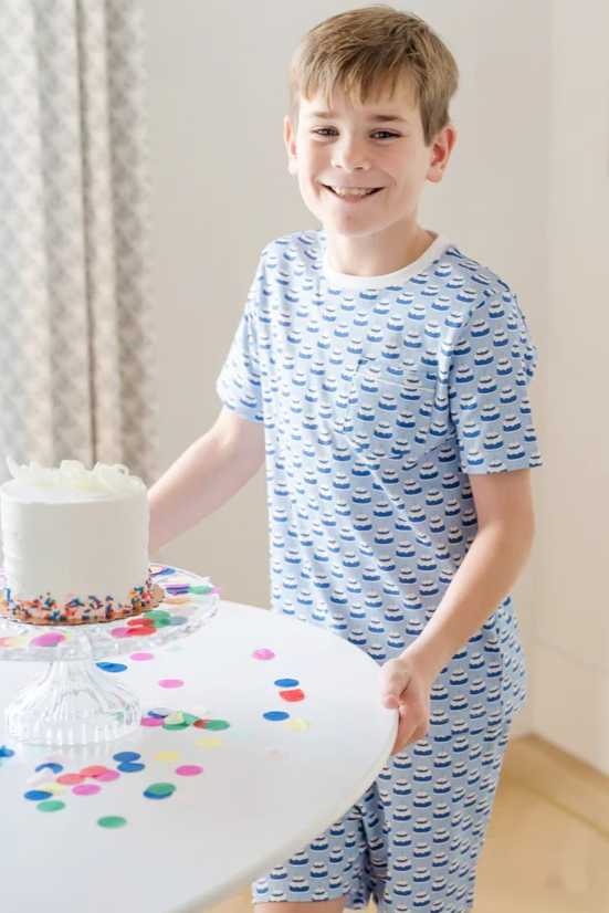 Celebrate his special day in style with the Charles Boys' Short Set in Birthday Cake Blue from Lila & Hayes. This playful pajama and loungewear set combines comfort and fun, making it perfect for birthday celebrations or everyday wear. Crafted with soft, breathable fabric, it keeps him cozy while adding a festive touch to his wardrobe. Make his birthday memorable with a set designed to delight both kids and parents alike.