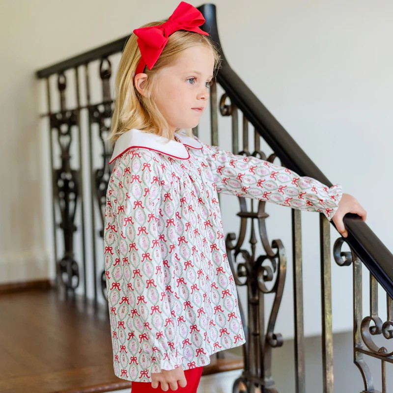Dress your little one in festive charm with the Morgan Set Girls' Legging Set - Nutcracker Ballet by Lila & Hayes. This playful print tunic & leggings outfit features a whimsical nutcracker ballet print with a classic Peter Pan collar, perfectly paired with vibrant red leggings. Designed for comfort and style, this set brings joyful holiday spirit to any occasion while allowing your child to move and play freely. Make holiday moments memorable with this delightful ensemble.