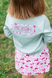 Meet the ultimate outdoor tee for adventurous girls and peace-of-mind moms! Girls' Pro Performance Long Sleeve T-shirt in Blue Surf with Pink Camo&nbsp;is made to move, protect, and play all day. Featuring our signature PRODOH logo with a pink camo border and "An Outdoor Tradition", this shirt adds a stylish twist to the functional favorite.