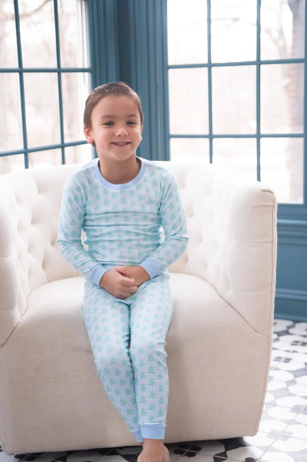 Dress your little one in festive comfort with these charming Boy's 2-Piece Blue Gingham Christmas Tree Zip Up Lounge Set from James & Lottie. Featuring a cheerful blue and white gingham pattern adorned with vibrant green Christmas trees, these cozy pajamas bring holiday magic to bedtime. Perfect for creating matching sibling moments during the holidays, these jammies combine classic Christmas style with everyday practicality your family will love.