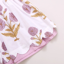Load image into Gallery viewer, Peek A Boo! Oversized wild dandelions bloom against a 100% cotton vintage cotton voile on our extra special Girls Marisol Dress. Full of surprises, this short sleeve vintage-inspired piece has a purple lining peeking out from behind the scalloped hem and a set of sparkly glitter buttons at the back. 
