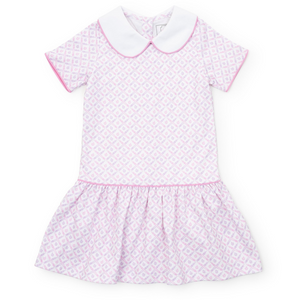 The Girl's School Plaid Pink Libby Dress by Lila &amp; Hayes combines classic charm with playful details. Featuring a pink and purple crayon and apple pattern, complemented by a crisp white Peter Pan collar and a stylish dropped waist, this dress is perfect for back-to-school days. Its vibrant colors and timeless design make it a favorite choice for your little girl’s wardrobe, blending comfort and style effortlessly.