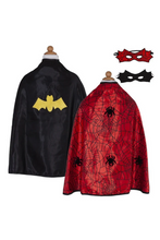Load image into Gallery viewer, This adorable reversible cape offers twice the fun with quality design and versatility. The black satin side features a yellow bat emblem and reverses to a red spider web satin print on the reverse side with large black velour foam spider details. The Velcro closure at the neck makes switching superheroes a breeze.
