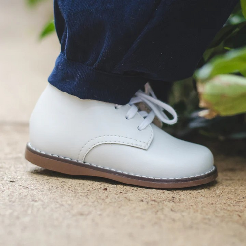Classic high-top leather bootie featuring lace closure. Offered in matte and pearlized colors; sizes ranging from 2.0 infant - 7.0 toddler.
Custom Fit System – Removable, dual insoles in Medium and Wide provided for customized fitting.
Roomy Toe Box – Allows tiny toes room to breathe and splay naturally during walking, enhancing balance and reducing rubbing, friction, and moisture.
Arch Support – Shoe last and insole designed to provide proper arch support for developing feet.
High-quarter design provides m