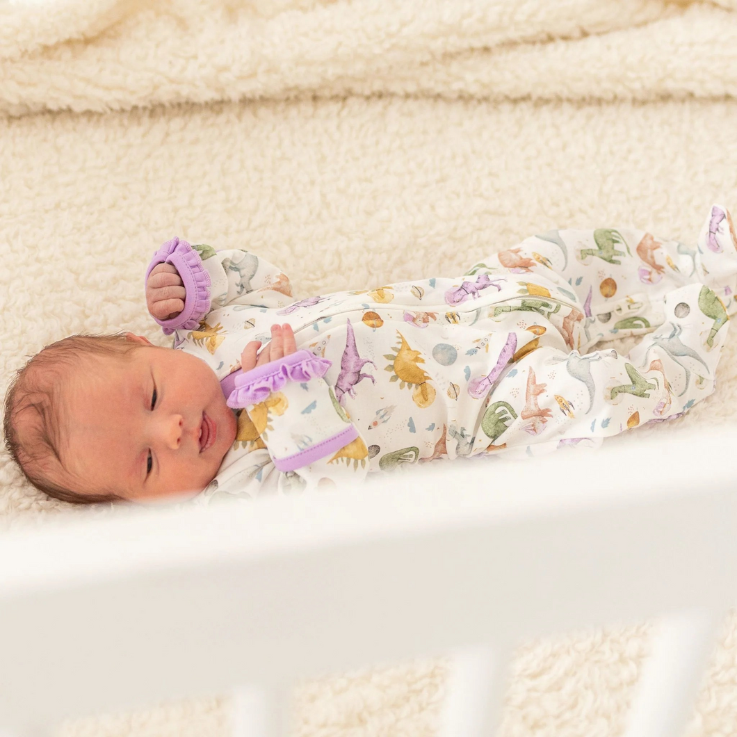 Blast off to bedtime with the Luna & Arlo Cosmic Dinos Zip Footie in Wisteria. Crafted from sumptuous Pima Cotton, this cozy footie wraps your little dreamer in cloud-soft comfort. Featuring an enchanting all-over print of adorable dinosaurs sporting space helmets, it sparks imagination even at rest. Wisteria accents on the trims and zipper bring a delightful pop of color that makes bedtime feel like an adventure. The convenient front zip makes diaper changes and bedtime routines effortless.