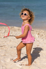 Load image into Gallery viewer, This swimsuit with a skirt captures the colors of the sunset with its vibrant pink and coral striped fabric, accented with playful white mini pompoms along the edge. Designed for comfort and ease, it features a tie at the back neck and quick-snap domes, making it perfect for young adventurers eager for seaside fun.
