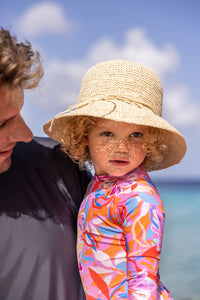 Make waves in style with our Blooming Sunset Rash Guard Skirted Swimsuit! This vibrant tropical print echoes the colors of golden hour, while the skirt waist and durable pink zip make for easy wear. From SnapperRock, it's ideal for young beach explorers seeking both fun style and practical comfort.