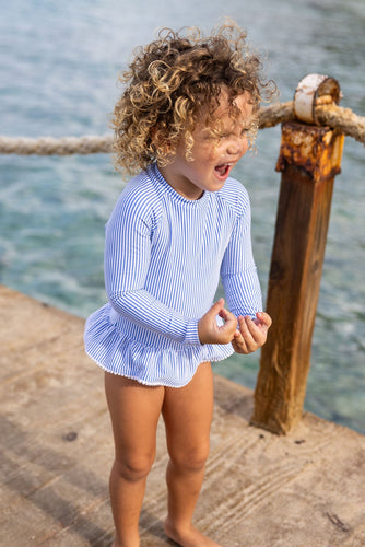 Experience elegance and sun safety with our Parisian Long Sleeve Skirted Swimsuit! Embrace classic blue and white seersucker stripes, charming white pompom trim, and a functional white back zip. This SnapperRock one-piece is perfect for infants who love to make a stylish splash.