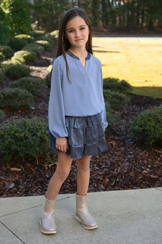 The Luna Skirt in Slate from Pleat offers a dazzling tiered design that adds sparkle to every step. Perfectly crafted for tween girls, this skirt pairs effortlessly with the Jane Textured Sweatshirt Top or Wren Top in Dashing, creating a stylish and versatile outfit. Its shimmering fabric makes it ideal for special occasions or everyday wear, giving your child a confident and playful look.