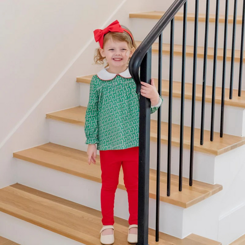 Dress your little one in festive charm with the Morgan Set Girls' Legging Set - Candy Cane Lane by Lila & Hayes. This playful outfit features a green tunic adorned with a whimsical candy cane print and a classic Peter Pan collar, perfectly paired with vibrant red leggings. Designed for comfort and style, this set brings joyful holiday spirit to any occasion while allowing your child to move and play freely. Make holiday moments memorable with this delightful ensemble.