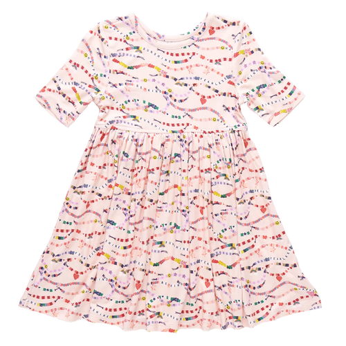 In our Friendship Bracelet Era! This exclusive new print from Pink Chicken, inspired by your favorite superstar, is a must-have for your stylish kiddos. This nostalgic print highlights positive messaging such as kindness, happiness and friendship - and is the perfect dress for class, a playdate, but most of all, your next concert. The classic Steph Dress silhouette is loved for its super swingy fully gathered skirt and skinny sleeve that hits right above the elbow. The soft and silky bamboo fabric is best k