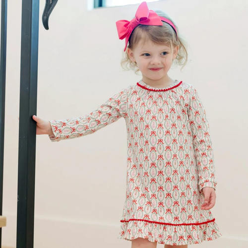 Dress your little one in enchanting elegance with the Carlin Girls' Dress featuring a charming Nutcracker Ballet print from Lila & Hayes. Made from soft, breathable long-sleeve pima cotton, it ensures comfort all day. The flutter ruffle hem and delicate pom pom trim add playful details, while the button closure at the back makes dressing effortless. Perfectly pairs with the matching Doll Dress for an adorable coordinated look that captures the magic of the season.